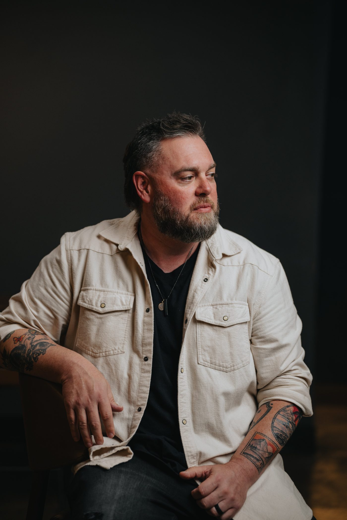 Drew Powell, seated, looking away from the camera